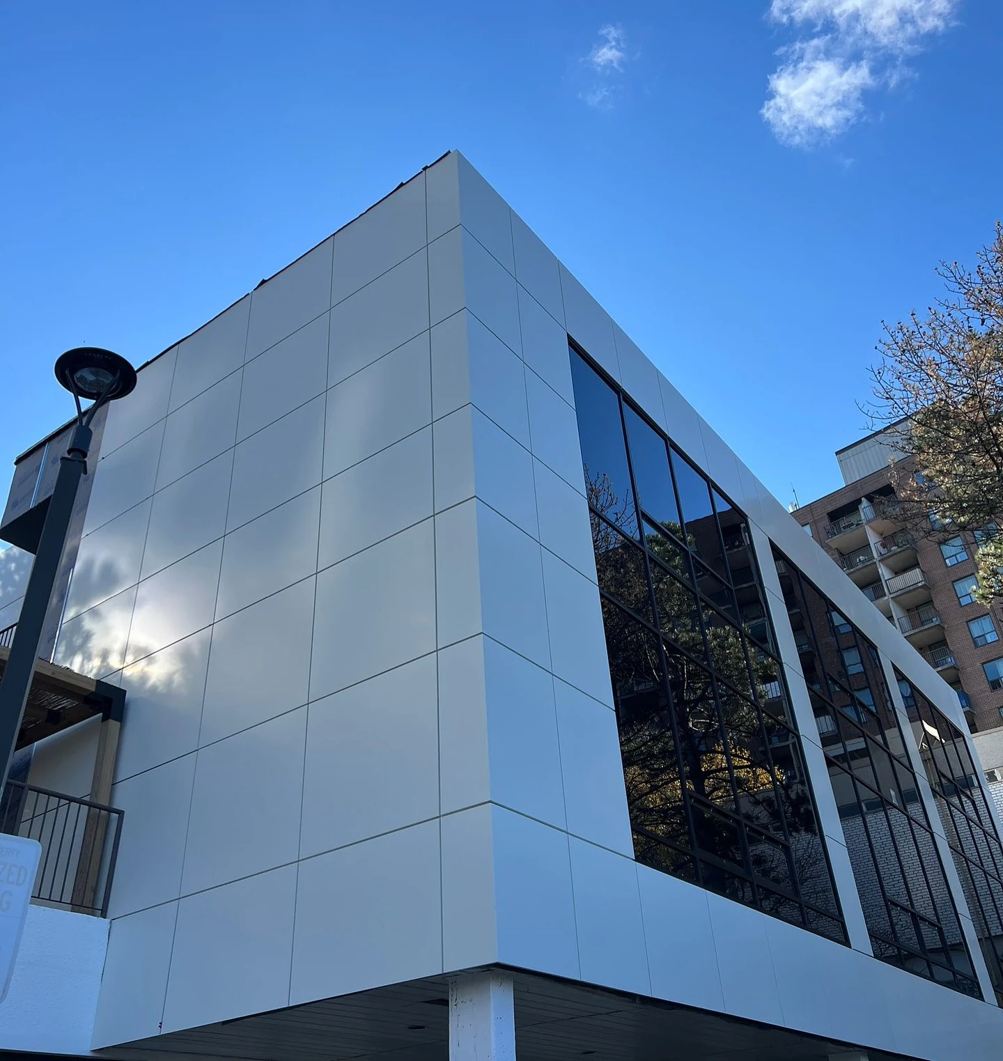 Close view of ACM panel corners meeting the glazed facade